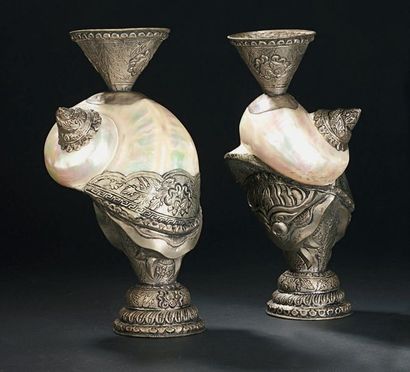TIBET - XXe siècle 
Deux coquillages montés en métal ciselé formant vase, à décor...