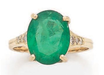 null Ring decorated with an oval emerald between two times three falling diamonds....