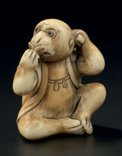 JAPON - Epoque MEIJI (1868-1912) 
Netsuke en ivoire, singe assis mangeant un kaki,...