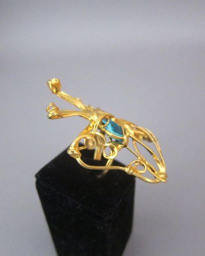 null Anonyme, Importante bague "papillon" en métal doré monture arabesques enserrant...