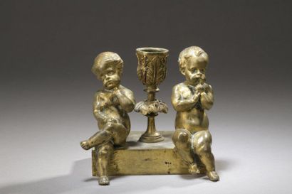  Petit flambeau en bronze doré à décor d'un 
couple d'Amours assis séparés par le...