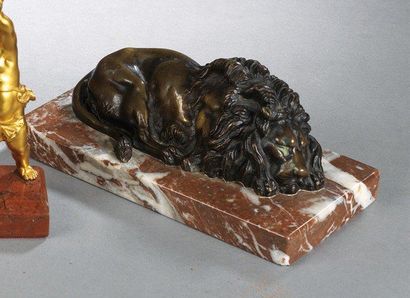 null Lion couché en bronze patiné sur socle en marbre rouge du Languedoc. XIX° siècle....