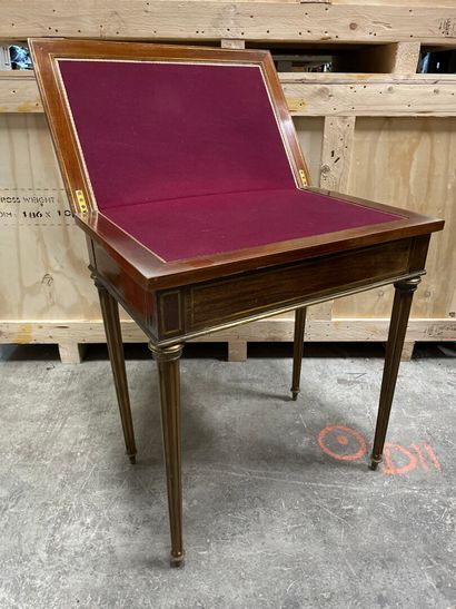 null A mahogany veneered game table inlaid with brass fillets, tapered legs with...