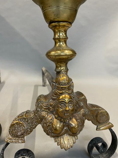null Pair of bronze andirons of baluster shape decorated with women's masks. 

Louis...