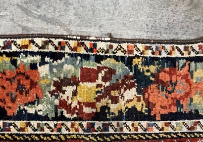  Tapis persan en laine, motifs de caissons fleuris sur fond bleu et marron. 
Usures....