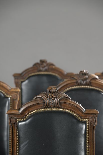 null 
Suite of ten carved walnut chairs with flat backs and foliage decoration, resting...