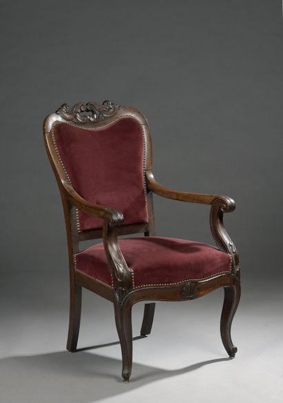 null A molded and carved mahogany cabriolet armchair, the top of the back decorated...