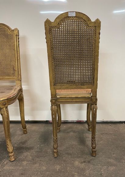 null Two gilded wood chairs carved with leaves, cane seats and back, console legs...