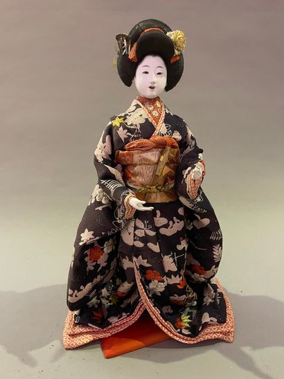 null Lacquered wood and fabric doll representing a Geisha.

Japan, 20th century....