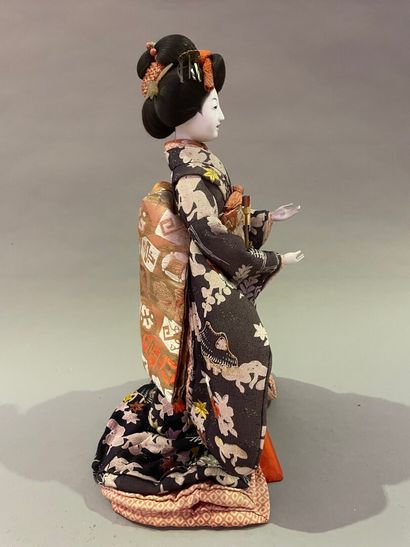 null Lacquered wood and fabric doll representing a Geisha.

Japan, 20th century....