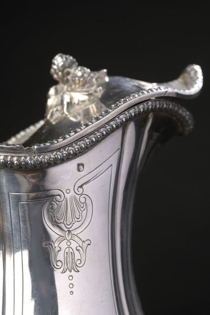 null Silver water jug of baluster form engraved with shells and flowers. The edge...