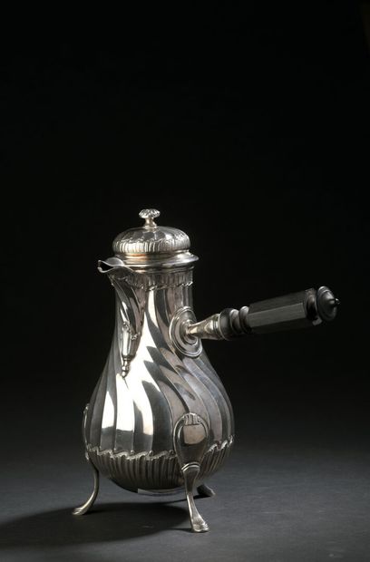 A baluster-shaped silver coffee pot with...