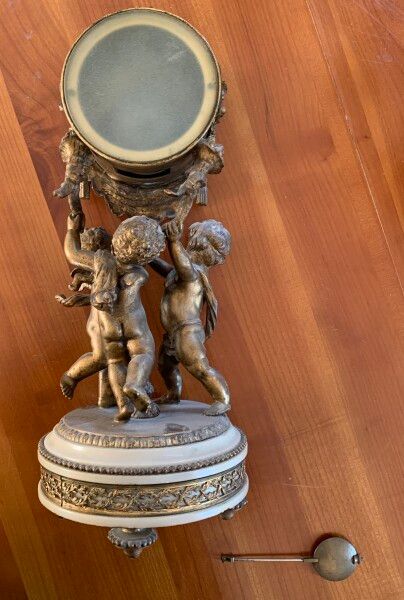 null Bronze and alabaster mantelpiece including a clock decorated with two cherubs...