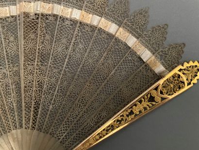 null Eventail en corne à décor ajouré, la monture en bronze doré.

Vers 1850.

H...