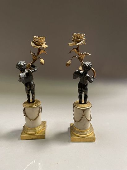 null Pair of gilt bronze, black patina bronze and alabaster candlesticks representing...