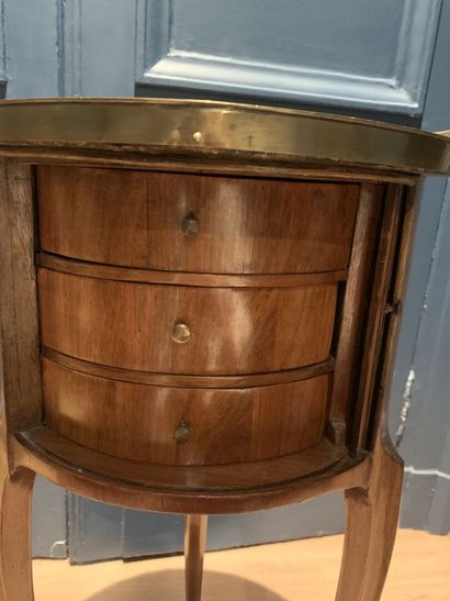 null Table drum in wood veneer with a flap to reveal three drawers. The top in marble...