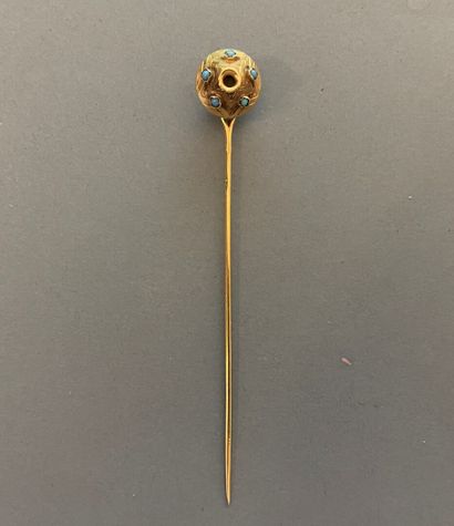 null Yellow gold tie pin with a circular pattern adorned with small turquoise beads.
Gross...