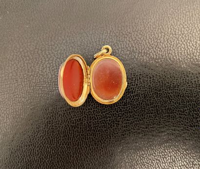 null Oval opening medallion pendant in sardonyx plates on yellow gold.
Gross weight:...
