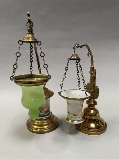 null Deux lampes à huile suspendues en laiton, l'une à fût décoré de porcelaine émaillée...