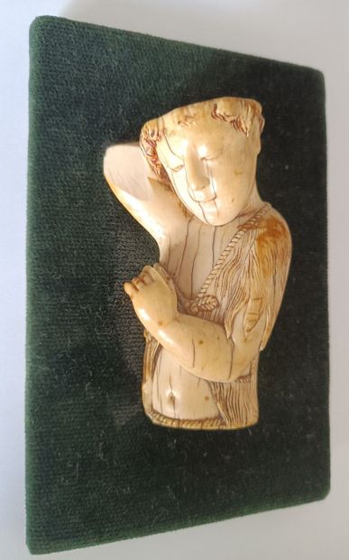 null High relief in ivory depicting a male figure in mid-body wearing a woolly tunic...