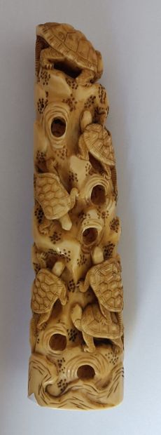 null Two subjects in ivory.

The first one shows a group of turtles climbing a rock...
