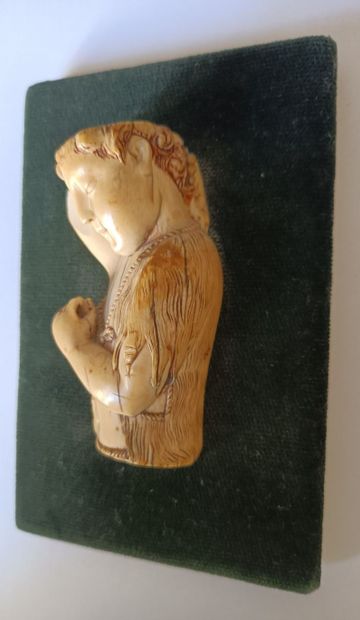 null High relief in ivory depicting a male figure in mid-body wearing a woolly tunic...