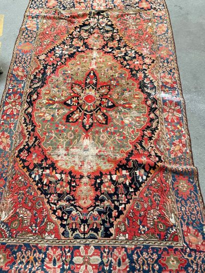 null 
Two woolen carpets, one with a red background decorated with a central medallion,

the...