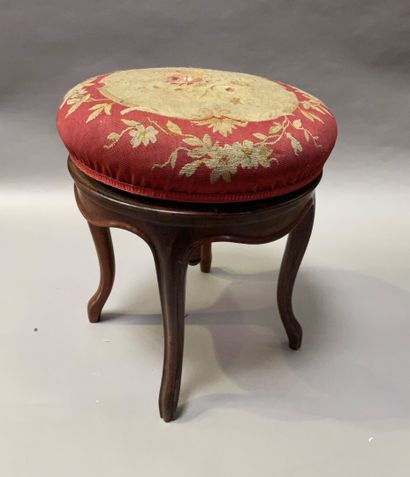 null Revolving piano stool with four cambered legs, upholstered in tapestry.

H:...