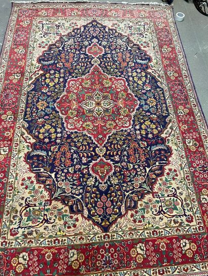 null Two wool carpets, one with a blue and red medallion motif on a beige background,...