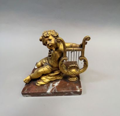 null A small gilded bronze putto musician, base in red marble with white veins.

Louis...