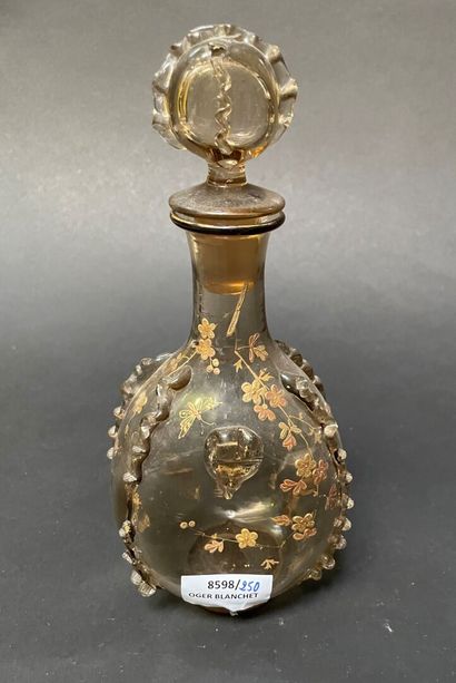 null Glass bottle with staples, gilded branches and butterflies.

In the taste of...