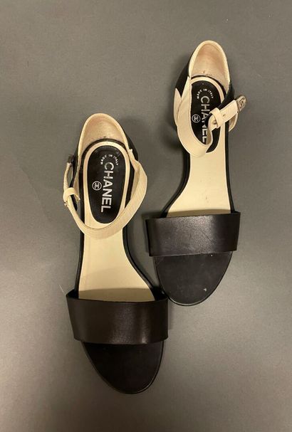 null CHANEL
Pair of two-tone black and white leather sandals with signature straps....