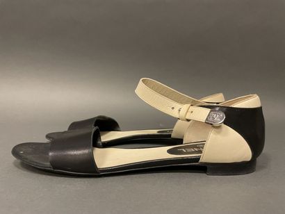 null CHANEL
Pair of two-tone black and white leather sandals with signature straps....
