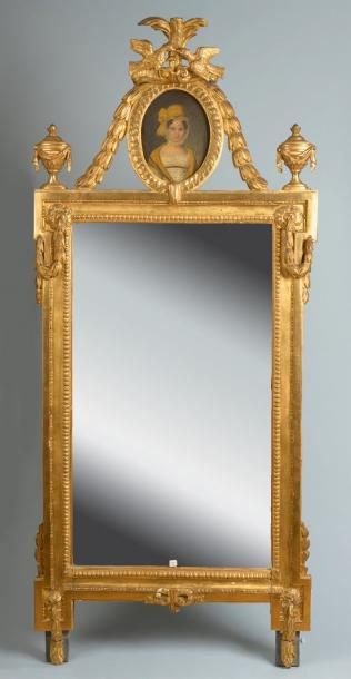 null Grand miroir en bois sculpté et doré, le fronton fronton orné d'un médaillon...