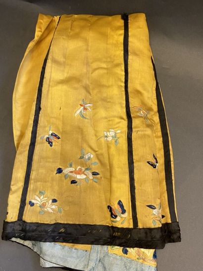 null CHINE, fin XIXe siècle. 
Jupe en soie jaune à décor de fleurs et papillons brodés....