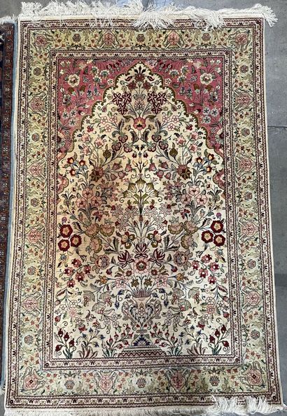 null Two rugs : 
- an oriental silk carpet on a beige background with flower motifs...