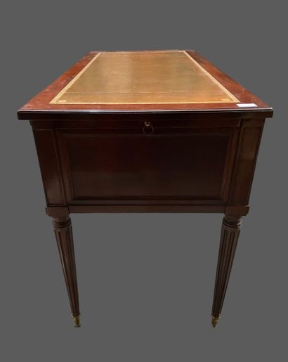 null Mahogany flat desk with three drawers in the waist, fluted tapered legs. 
Louis...
