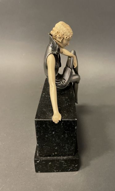 null In the Art Deco style. 
Seated woman
Metal and resin sculpture on a marble base....