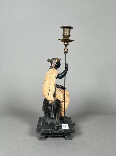 null A painted regula candleholder with a seated Egyptian figure.
Height: 37.5 cm...