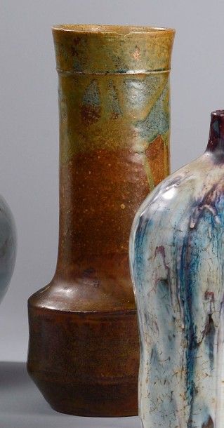 Eugène LION (1867-1945) Vase en grès à corps cylindrique et long col. Émail marron...