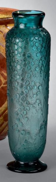 DAUM Vase à corps cylindrique épaulé sur talon débordant. Épreuve en verre bleu à...