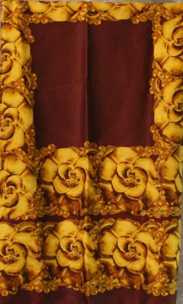 CHANEL Foulard en soie à décor de fleurs or sur fond bordeaux.