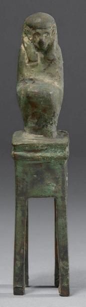 null Figurine de Maât assise sur une sellette quadripode. Bronze à patine verte....