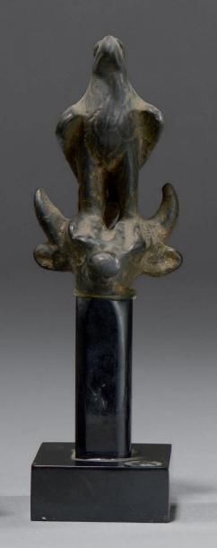 null Fragment de figurine représentant une tête de taureau surmonté d'un aigle. Bronze...