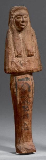  Shaouabti portant la large perruque tripartite. Il est inscrit sur une colonne ventrale...