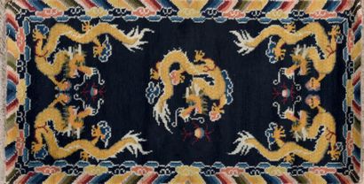 CHINE Tapis rectangulaire en laine, à décor de cinq dragons, dont un au centre, pourchassant...