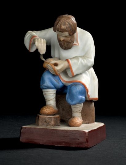RUSSIE, MOSCOU Statuette en biscuit polychrome représentant un savetier assis travaillant...