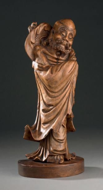 CHINE - Début XXe siècle Statuette d'immortel debout en bois sculpté, les mains cachées...