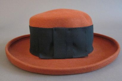 null Un chapeau melon orange, cerclé d'un ruban noir avec un noeud plat (taille 56)....