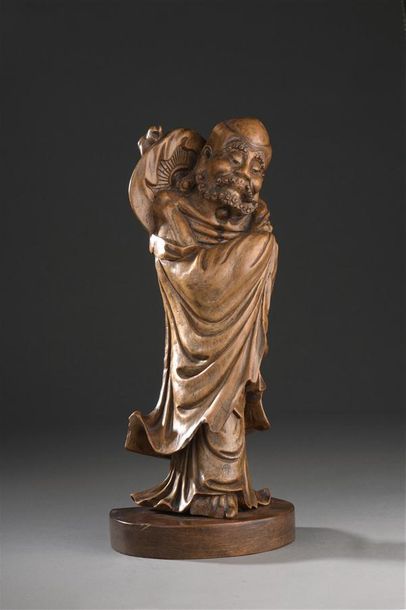 null CHINE - Début XXe siècle

Statuette d'immortel debout en bois sculpté, les mains...